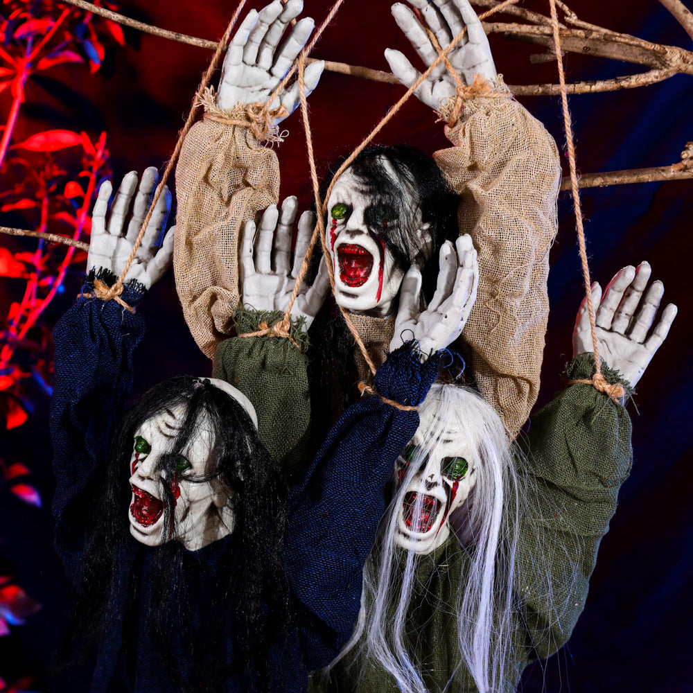 Gros plan des visages grimaçants et des mains levées de trois fantômes décoratifs pour Halloween.
